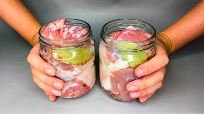 Nakládané vepřové maso ve sklenici s bobkovým listem a česnekem