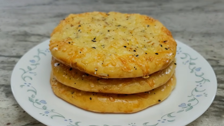 Jednoduché domácí pečené chlebové placky sypané sýrem a semínky